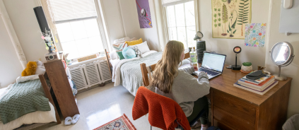 Photo of student sitting at desk in residence hall room